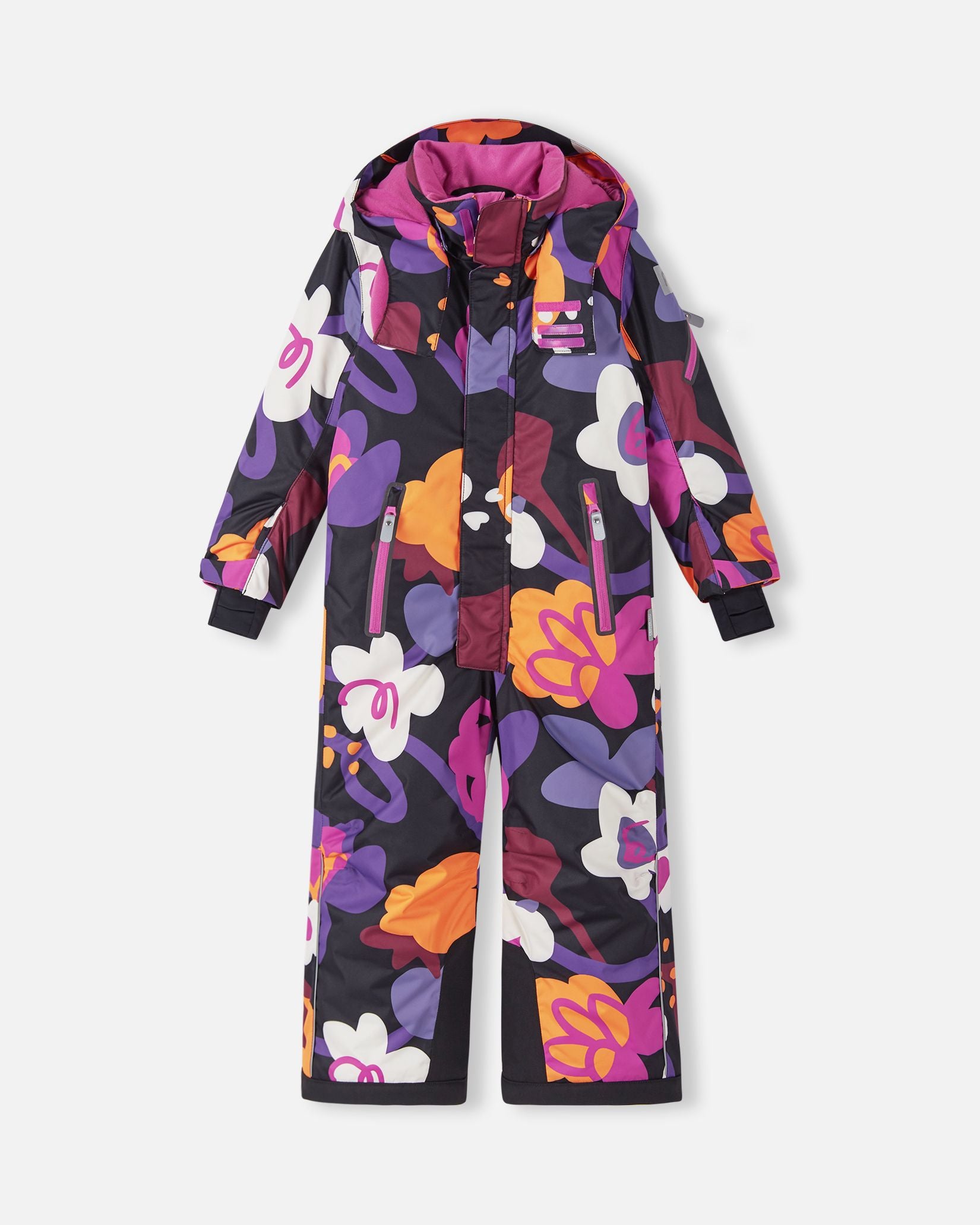 Front view of the Reima Reach kids' winter ski suit in a bright black, purple, orange, and pink floral pattern, featuring secure zippered chest pockets, heavy-duty black reinforced lower leg hems, and a cozy attached winter hood.
