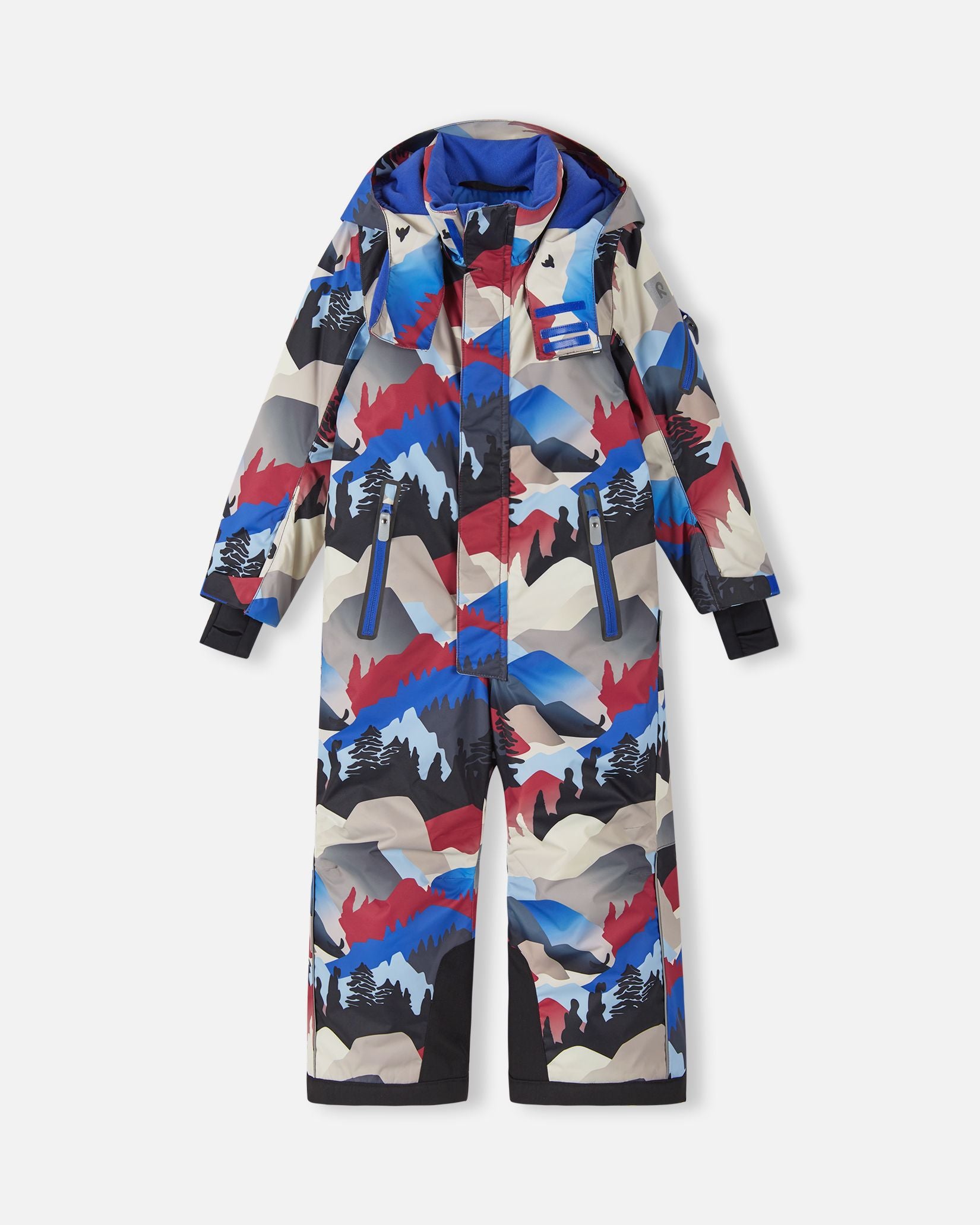 Front view of the Reima Reach kids' ski suit in a soft black, red, and blue mountain landscape print, featuring dual zippered chest pockets, heavy-duty black reinforced lower legs, and a protective winter hood designed for active snow sports.