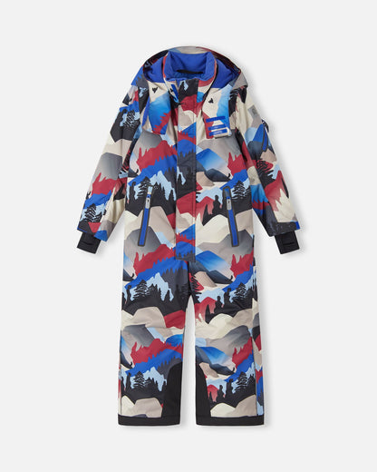 Front view of the Reima Reach kids' ski suit in a soft black, red, and blue mountain landscape print, featuring dual zippered chest pockets, heavy-duty black reinforced lower legs, and a protective winter hood designed for active snow sports.