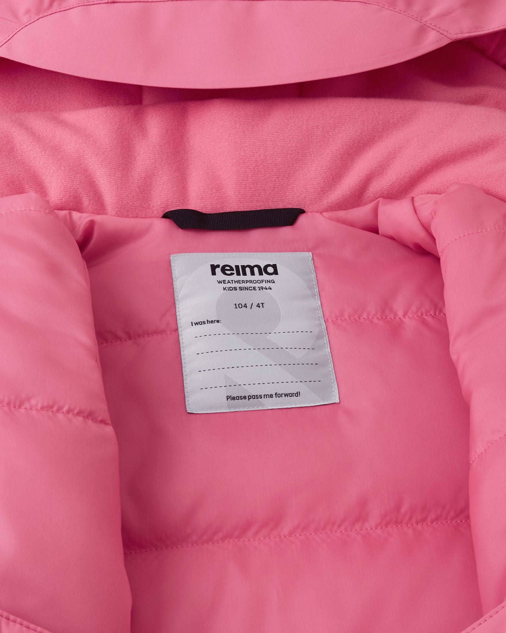 Inside collar view of the soft coral Reima Reach ski suit, displaying the warm fleece lining and a dedicated name tag with lines for multiple children to encourage sustainable hand-me-downs.