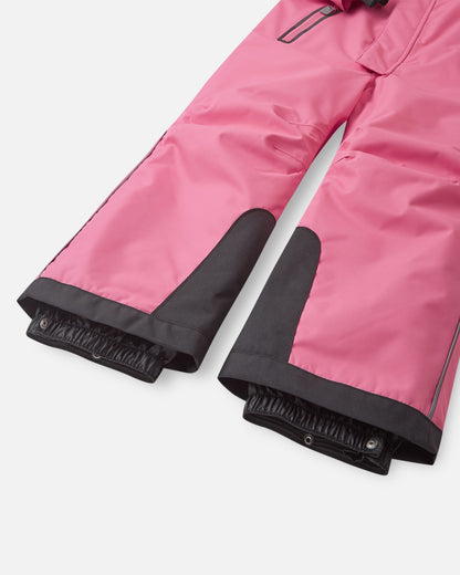 Detail shot of the lower legs on the Reima Reach kids' ski suit, showing the ultra-durable black reinforced kick patches and inner elastic snow gaiters designed to stretch tightly over ski boots.