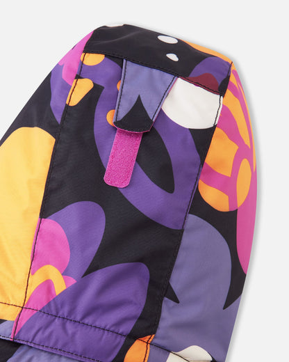 Detail view of the back of the hood on the Reima Reach kids' ski suit, showing a bright pink velcro adjustment strap that allows parents to easily customize the hood depth for a secure, safe fit over a ski helmet or winter beanie.