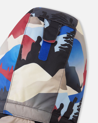 Detail shot of the back of the hood on the Reima Reach kids' ski suit, displaying a practical blue velcro adjustment strap that allows parents to easily customize the hood depth for a secure fit over a winter beanie or ski helmet.