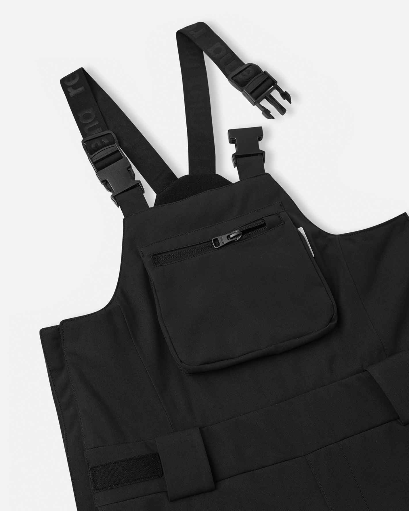 Close-up detail of the upper torso on the black Reima Rehti kids' snow bibs, highlighting the sturdy adjustable buckled suspenders, comfortable high-back design, and a secure zippered chest pocket for small essentials.