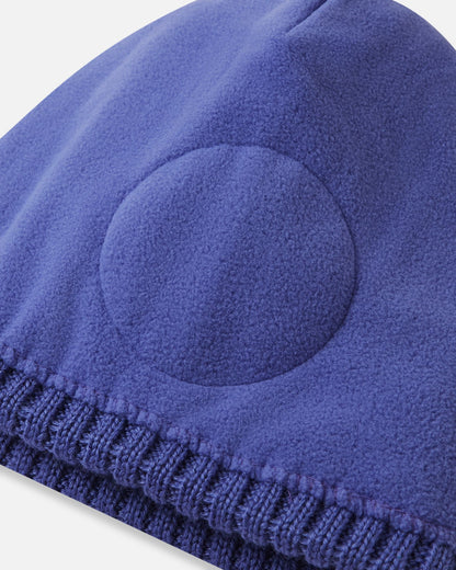 Inside detail shot of the breezy violet Reima Routii kids' beanie, highlighting the ultra-soft full fleece lining and the specialized circular windproof earpiece inserts engineered for optimal thermal regulation on the slopes.