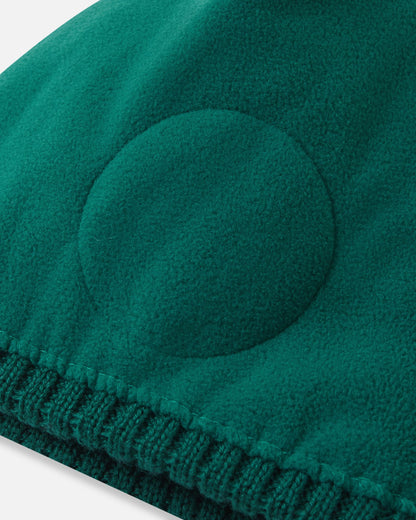 Inside detail shot of the deeper green Reima Routii kids' beanie, highlighting the ultra-soft full fleece lining and the specialized circular windproof earpiece inserts engineered for optimal thermal regulation in the snow.