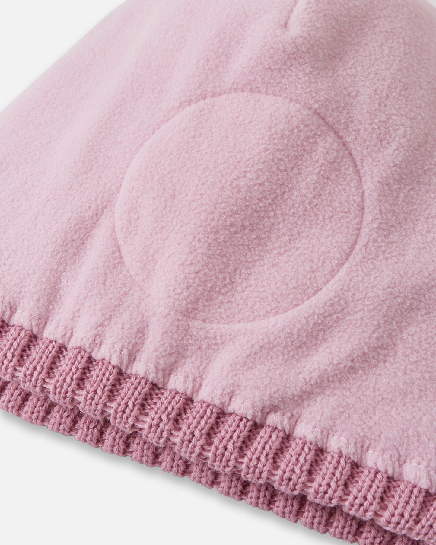 Detailed interior view of the grey pink Reima Routii kids' beanie. The image reveals the fully lined, soft thermal fleece interior and the specialized circular windproof earpiece inserts designed to protect children's ears from cold winter winds.