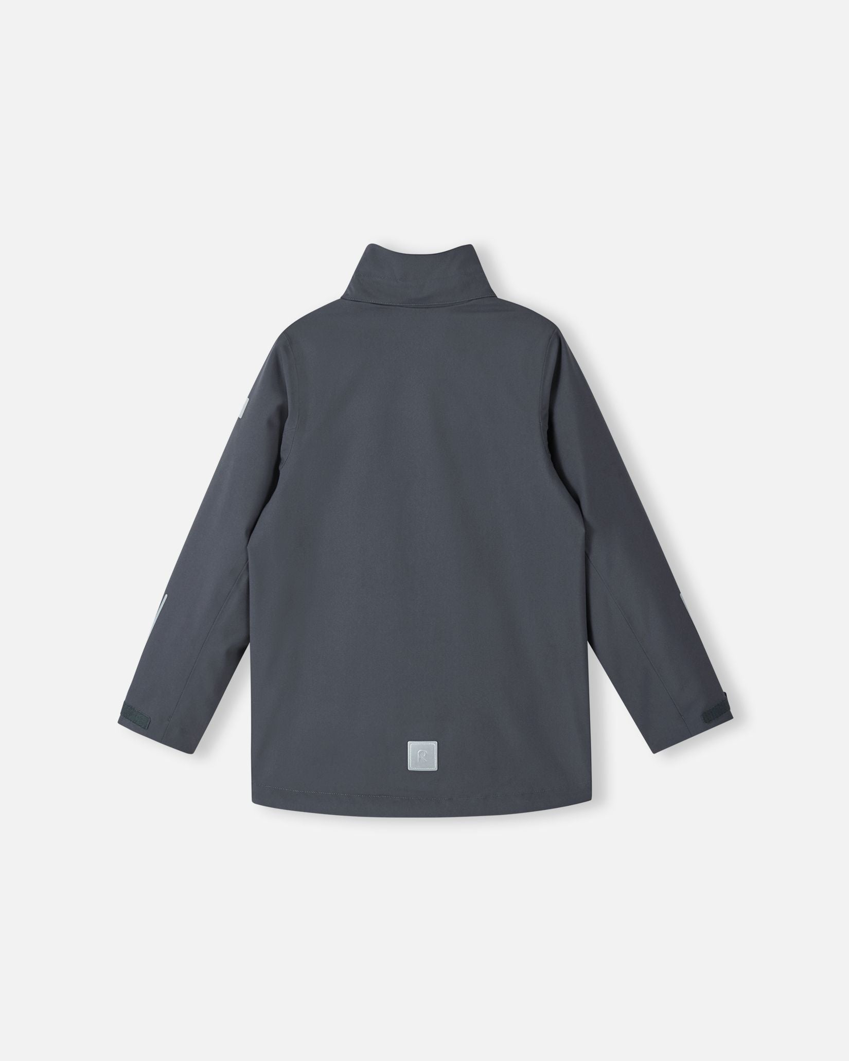 Back view of the Reima Saarela kids waterproof fall jacket in soft black, shown without the detachable hood to display the high protective collar. Features include a visible lower-back reflective patch and adjustable sleeve cuffs.