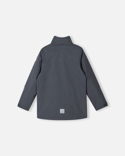 Back view of the Reima Saarela kids waterproof fall jacket in soft black, shown without the detachable hood to display the high protective collar. Features include a visible lower-back reflective patch and adjustable sleeve cuffs.