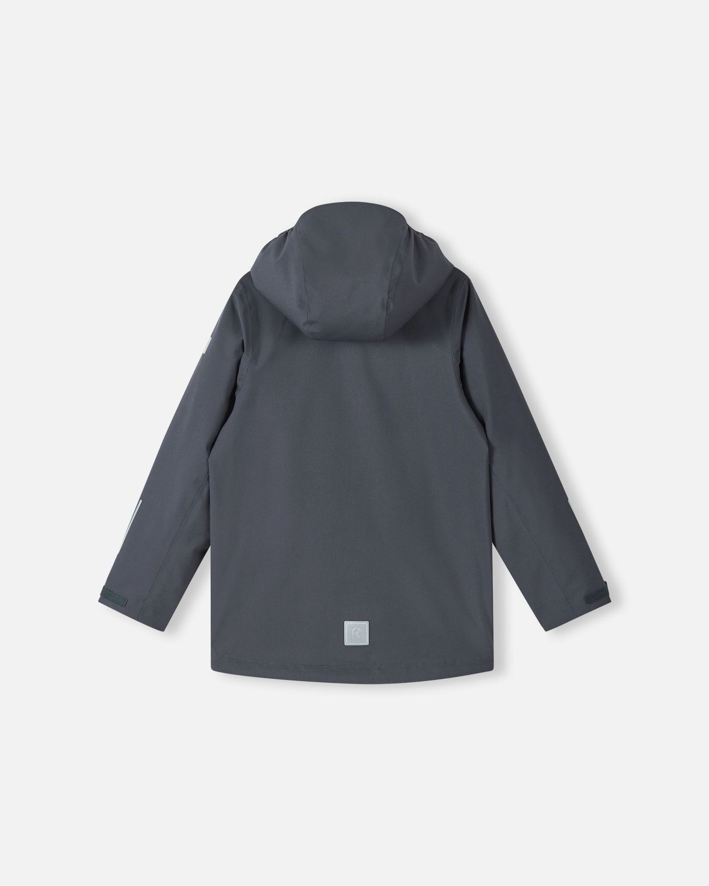 Back view of the Reima Saarela kids waterproof fall jacket in soft black, with the detachable protective hood attached and visible reflective patches on the lower back and sleeve. This jacket is Iisisti fleece compatible via a zip-in system.