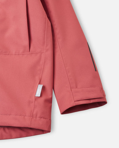 Detailed close-up of the sleeve on the Reima Saarela kids' red clay shell jacket, focusing on the adjustable hook-and-loop cuff, reflective safety detail, and the Reimatec waterproof technology tag.