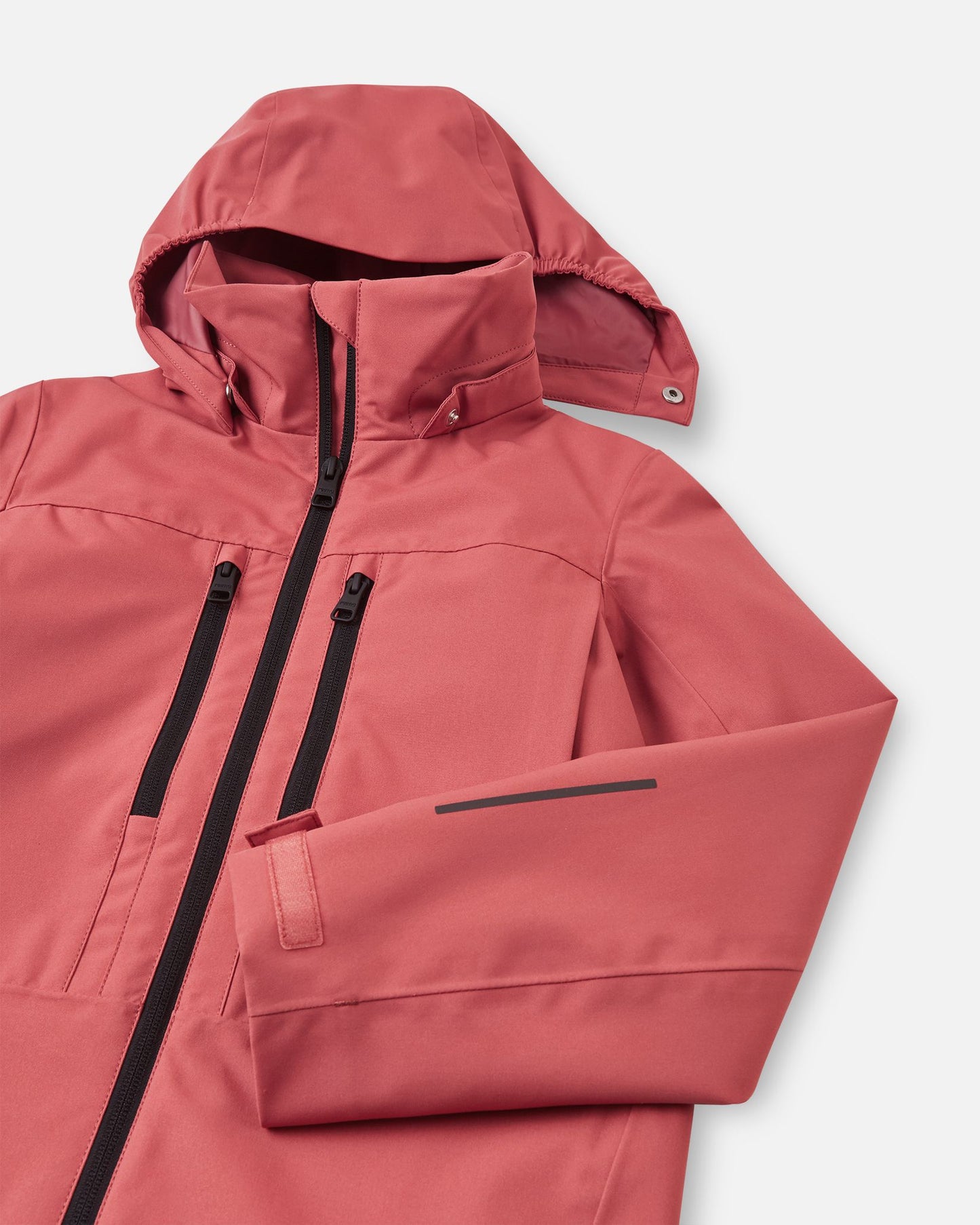Close-up of the upper chest and hood on the Reima Saarela kids' red clay shell jacket, showcasing the protective high collar and the secure snap attachments for the safe, detachable hood.
