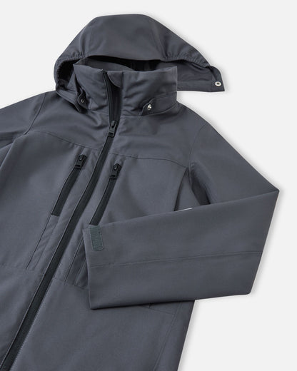Close-up of the detachable, weather-protective hood and high collar on the soft black Reima Saarela kids waterproof jacket.