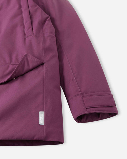 Close-up of the sleeve cuff with adjustable Velcro strap and the lower pocket on the deep purple Reima Serkkula parka, featuring the sewn Reimatec waterproof label.