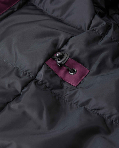 Close-up of the interior lining of the deep purple Reima Serkkula kids' parka, showing smooth black down baffles, a reinforced purple fabric patch, and an elastic waist adjustment toggle.