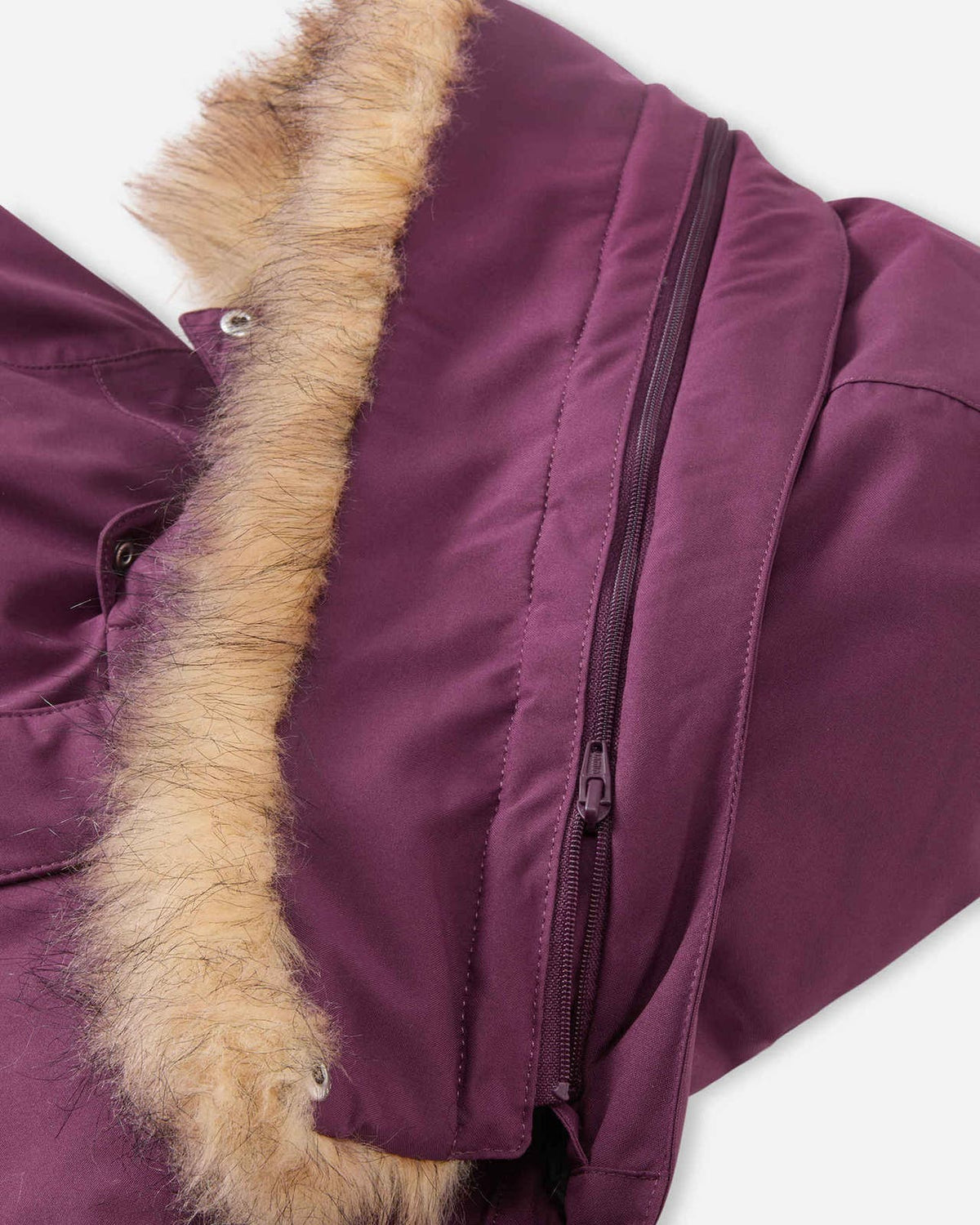 Detail view of the detachable hood construction on the deep purple Reima Serkkula kids' down parka, showing the zip-off faux-fur border and snap-button collar attachment.