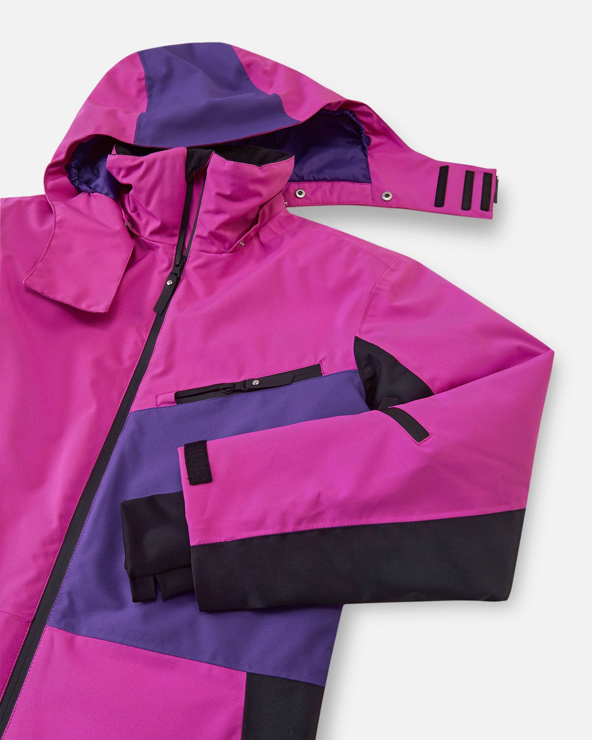 Close-up of the upper half of the Reima Skaulo girls ski suit in fuchsia, showing the adjustable detachable hood, purple accent paneling, and continuous front zipper.