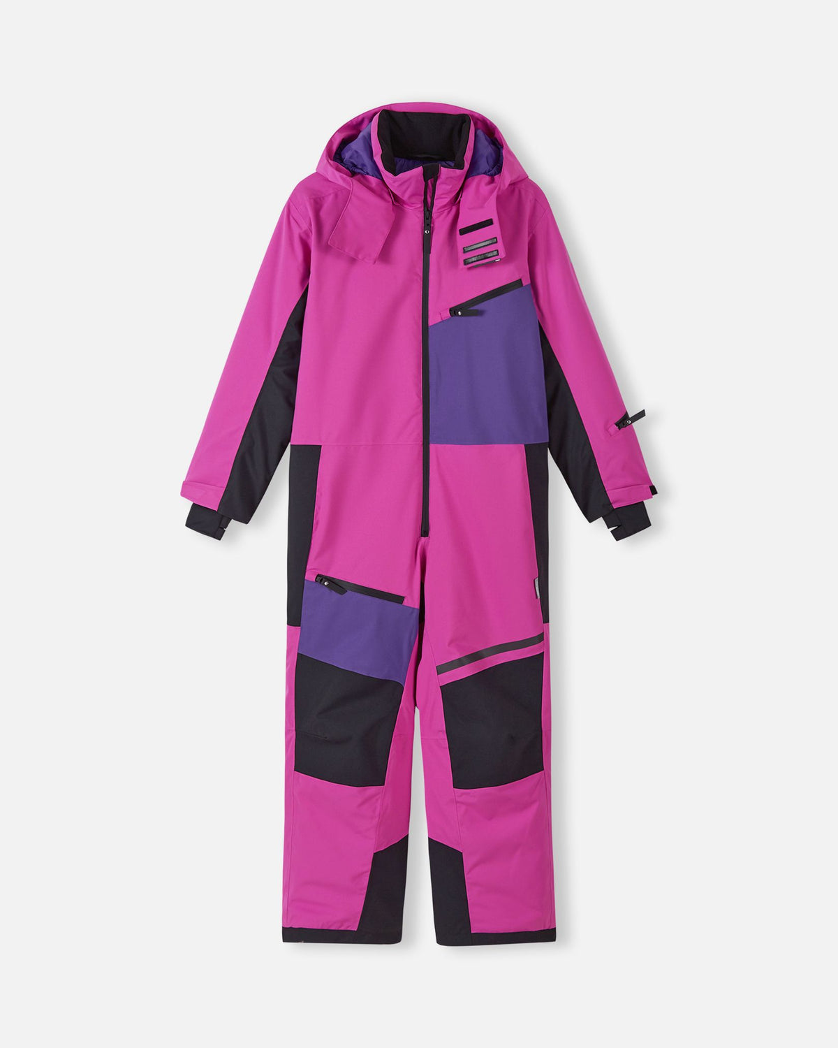 Front view of the Reima Skaulo girls ski suit in bright fuchsia, featuring purple and black color-blocked panels, a front zipper, and a secure zippered chest pocket.