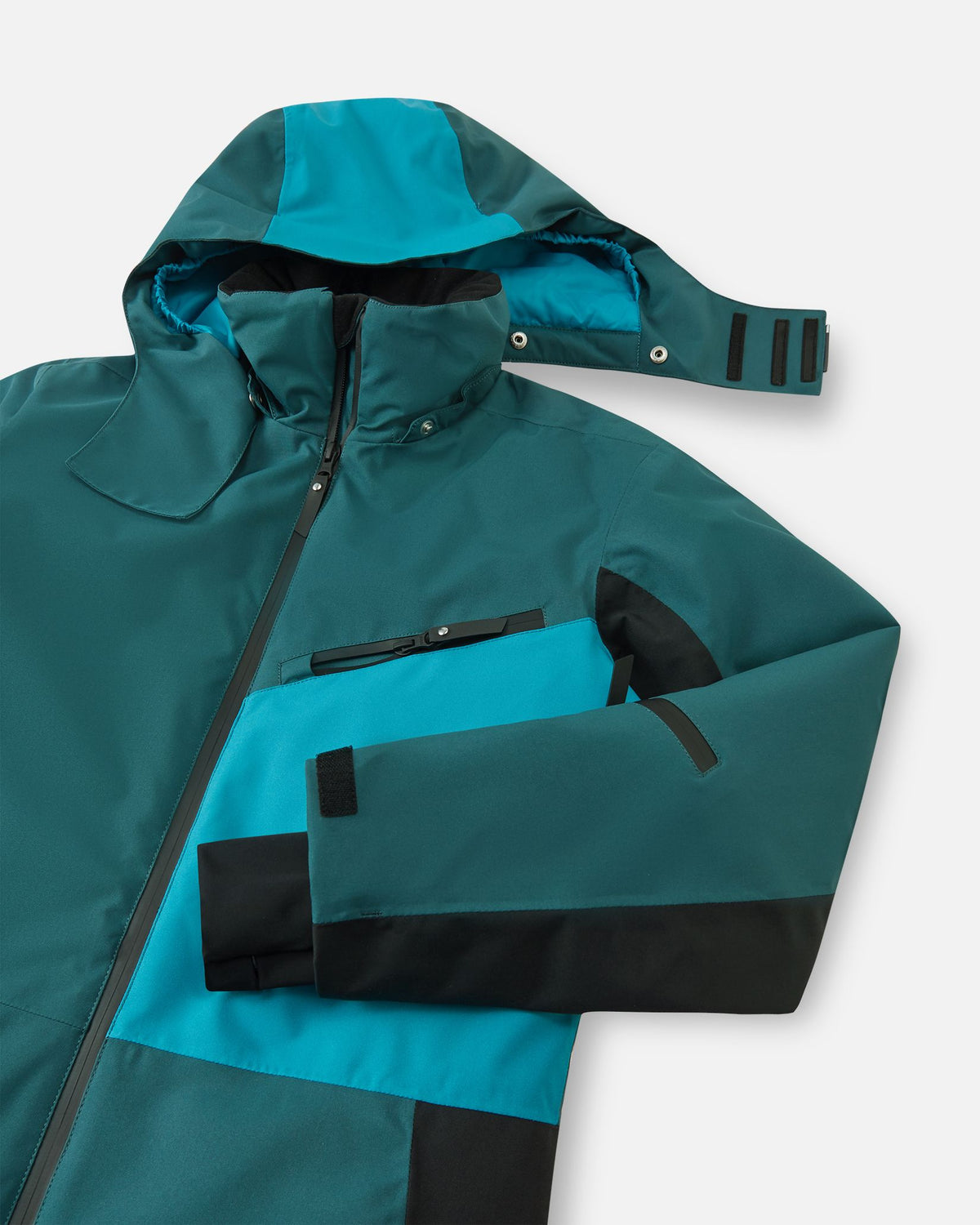 Close-up of the upper half of the Reima Skaulo kids' ski suit, showcasing the smooth front zipper, a secure water-resistant chest pocket, adjustable velcro sleeve cuffs, and the safe, snap-button detachable hood.