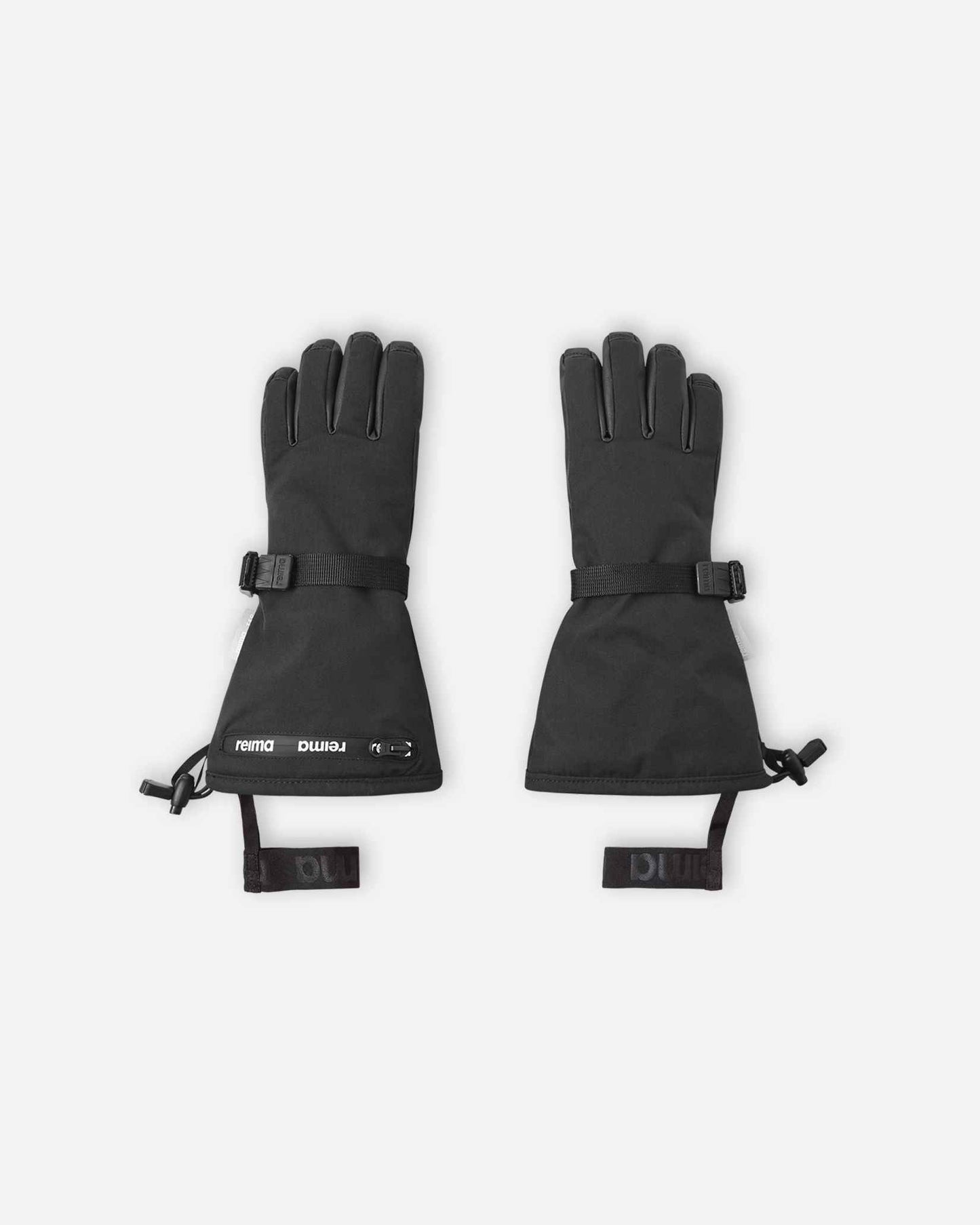 Flat lay view of the backs of the classic black Reima Skimba kids' ski gloves, featuring an extra-long snow-blocking gauntlet cuff, an adjustable wrist strap, and elastic safety wrist leashes.