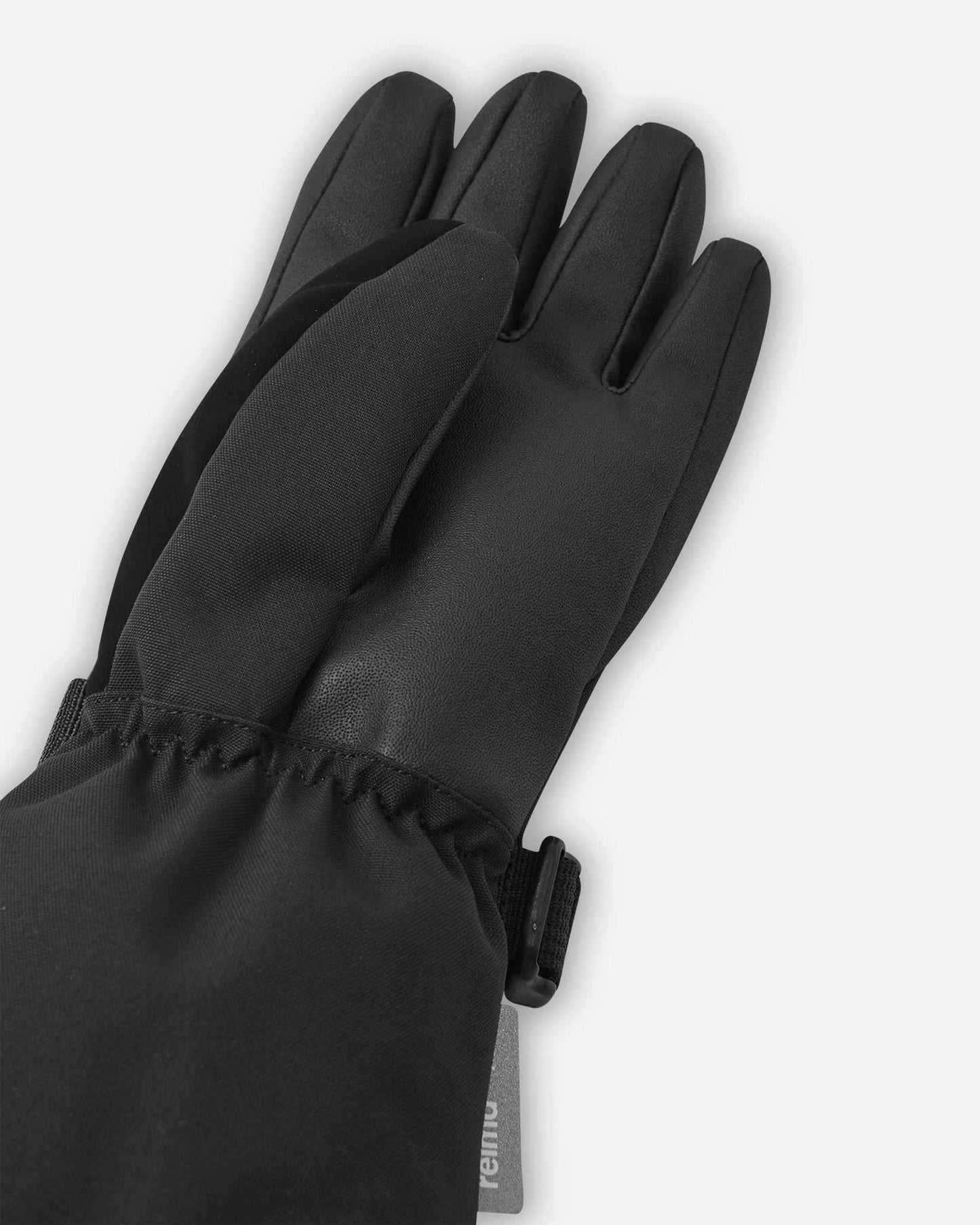 Close-up detail of the reinforced thumb and palm material on the black Reima Skimba kids' ski gloves, engineered for ultimate durability and physical dexterity on the slopes.