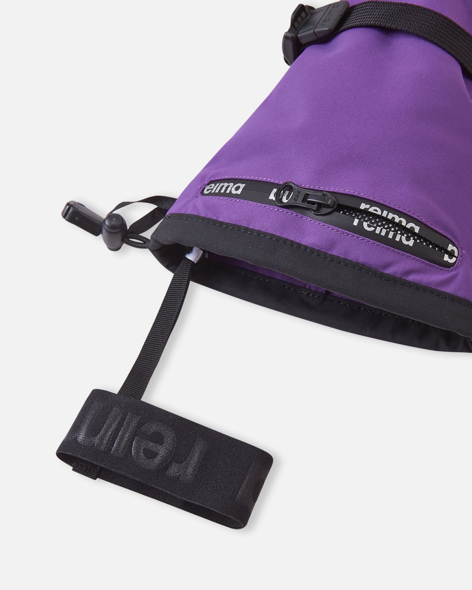 Close-up detail of the long cuff on the plum purple Reima Skimba kids' ski gloves, highlighting the convenient water-resistant zippered ski pass pocket and the attached elastic wrist leash to prevent dropped gloves.