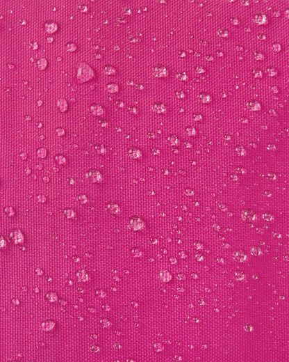 Macro close-up of water droplets actively beading off the rosy berry pink outer shell of the Reima Skimba kids' ski gloves, highlighting the highly effective waterproof and snow-repellent technical fabric.