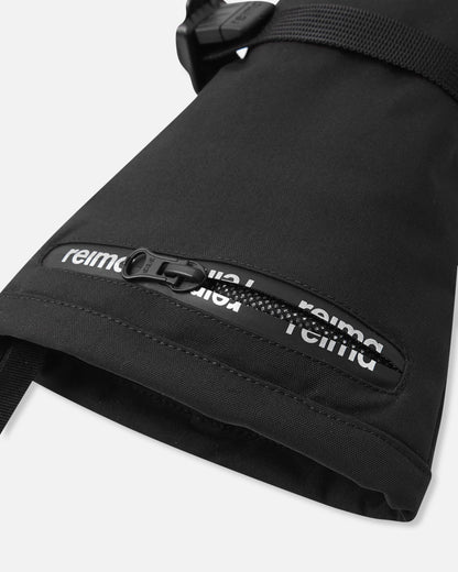 Close-up detail of the extra-long cuff on the black Reima Snoukka kids' ski mittens, highlighting the convenient water-resistant zippered ski pass pocket featuring the Reima logo.