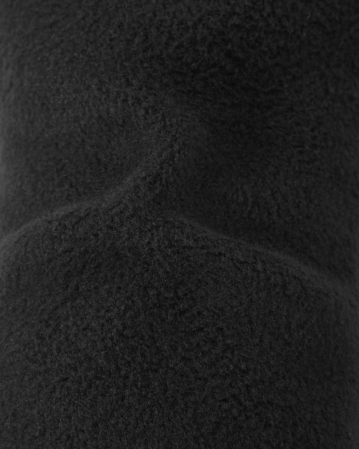 Macro close-up of the soft, thick black thermal fleece inner lining inside the Reima Snoukka kids' ski mittens, engineered to provide maximum warmth and comfort during cold weather winter sports.
