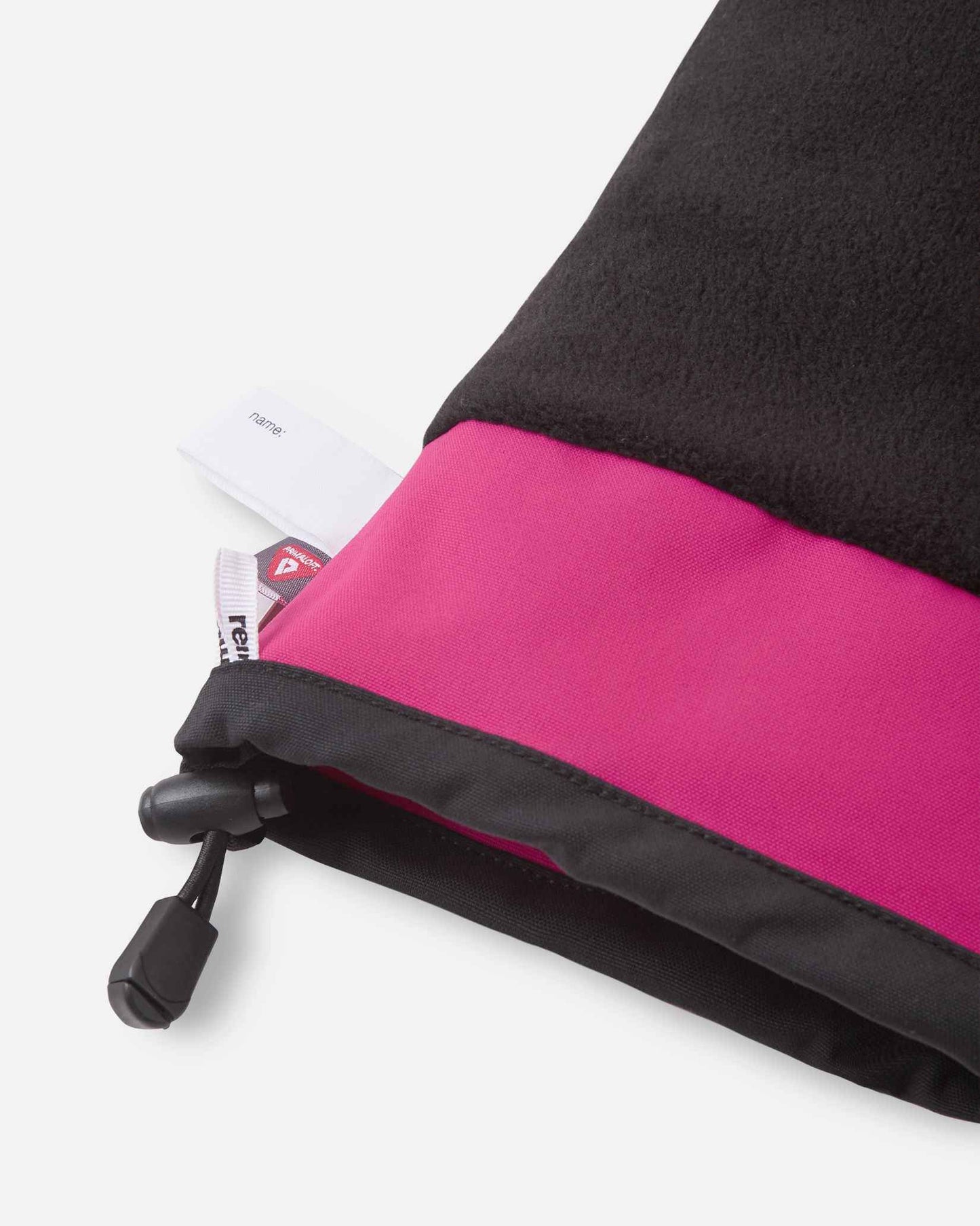 Detail of the inner cuff of the rosy berry pink Reima Snoukka kids' ski mittens, showing the soft black thermal fleece lining, a built-in customizable name tag, and the premium PrimaLoft insulation label indicating high-performance winter warmth.