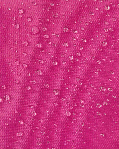 Macro close-up of water droplets actively beading off the rosy berry pink outer shell of the Reima Snoukka kids' ski mittens, highlighting the highly effective waterproof and snow-repellent technical fabric.