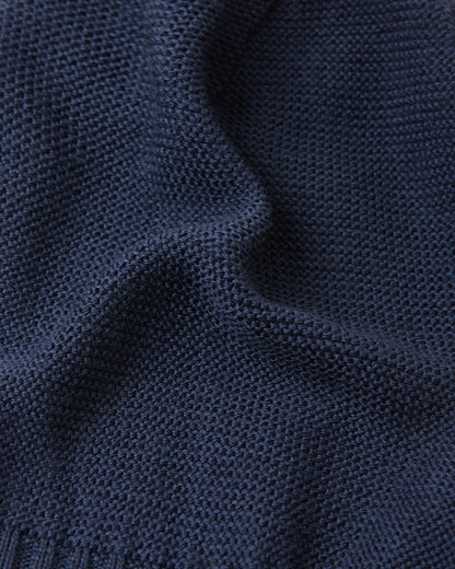 Macro photograph of the navy Reima Starrie kids' balaclava material, displaying the tightly woven, temperature-regulating merino wool knit that naturally wicks moisture.