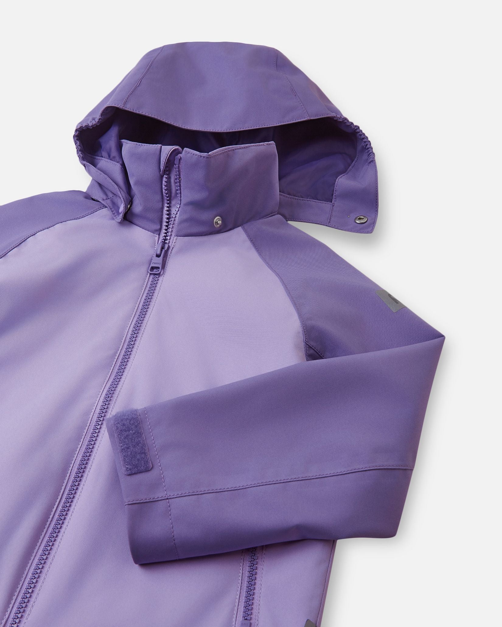 Close-up of the child-safe detachable hood on the blooming lilac Reima Sulkava fall jacket, illustrating the durable snap buttons designed to release easily if the hood gets caught during outdoor play.