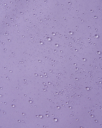 Macro close-up showing water droplets beading tightly on the blooming lilac Reimatec fabric of the Sulkava girls' fall jacket, demonstrating its advanced waterproof and rain-resistant qualities.