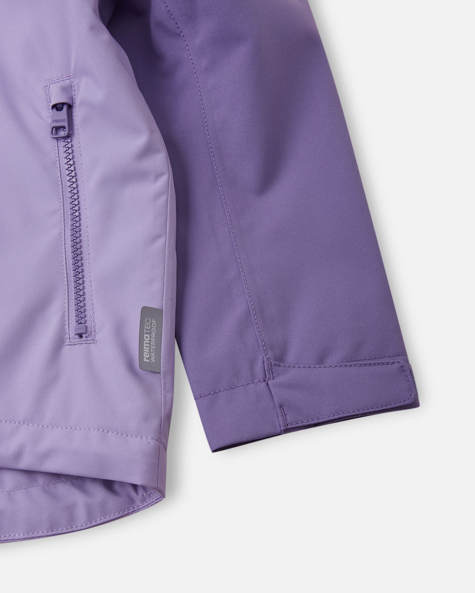 Detail shot of the blooming lilac Reima Sulkava jacket, highlighting a smooth-running zippered side pocket, a Reimatec waterproof tag, and an adjustable velcro wrist cuff for a secure, draft-free fit.