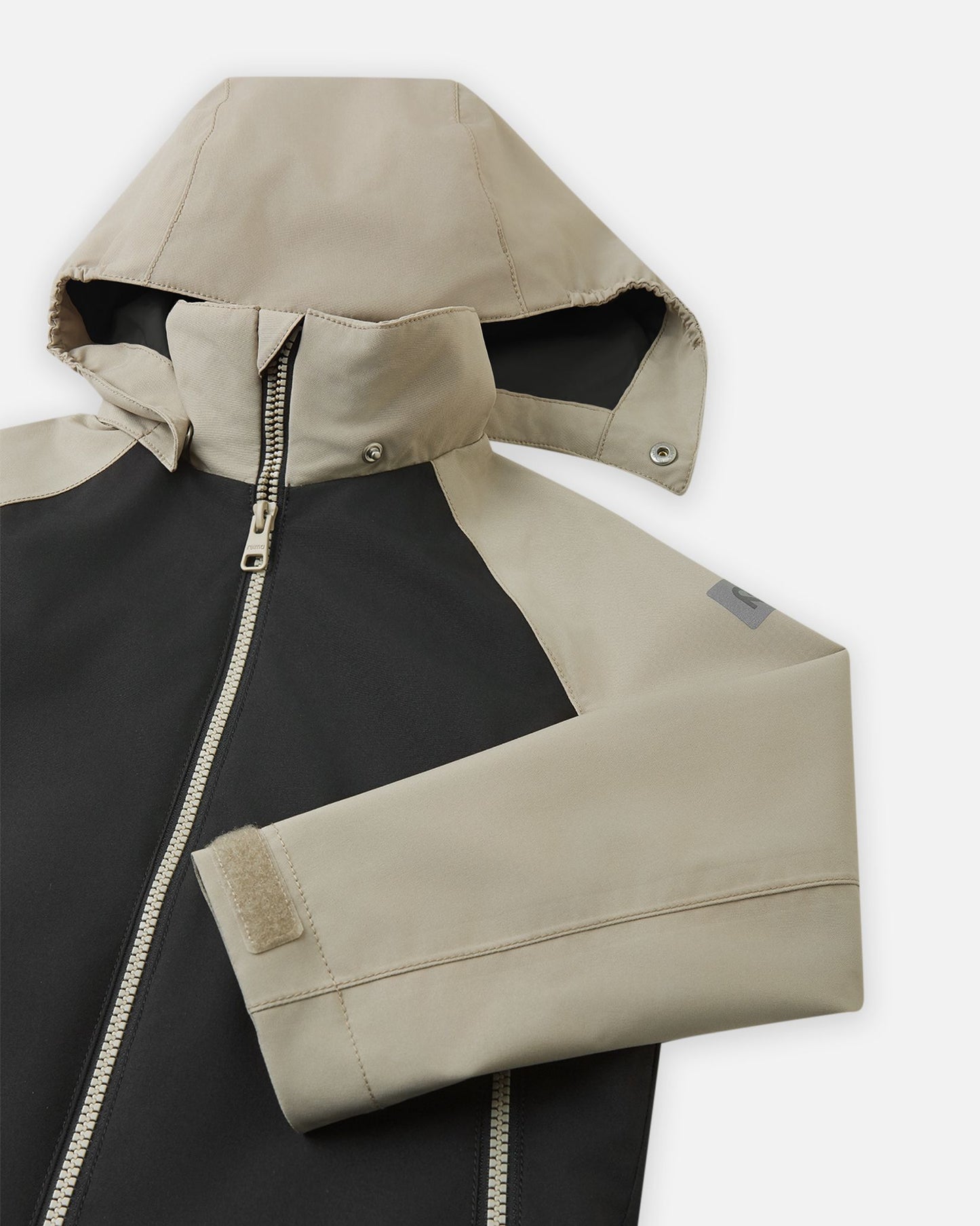 Close-up of the child-safe detachable hood on the Reima Sulkava fall jacket, illustrating the durable snap buttons that easily release if the hood gets caught while a child is playing.