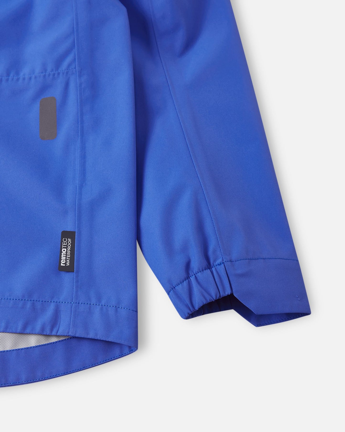 Close-up of the elastic sleeve cuff on the sparkly blue Reima Suojala kids jacket, highlighting the Reimatec waterproof technology label.