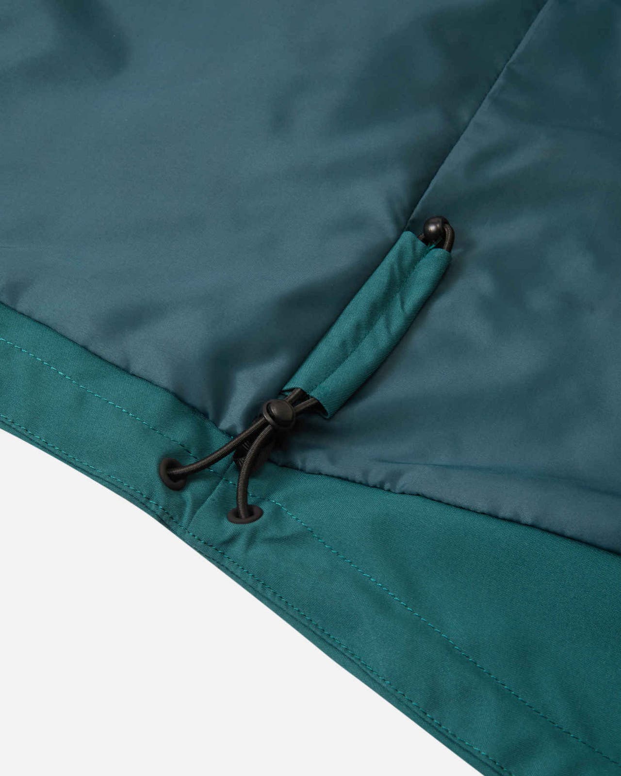Close-up of the interior adjustable bungee cord hem on the Reima Syddi kids' 3-in-1 jacket, designed to seal out wind and snow.