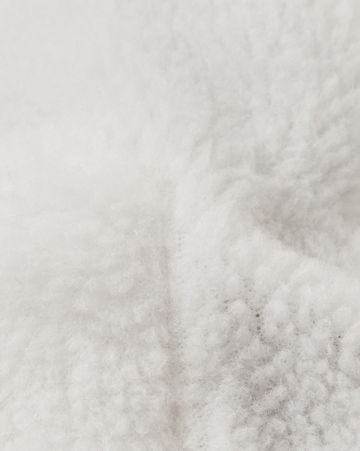 Extreme close-up of the plush white interior lining used in Reima Tassuin toddler winter mittens, crafted from a warm 41% wool and 59% polyester blend engineered to provide maximum thermal insulation and comfort for young children in the snow.