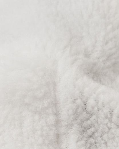 Extreme close-up of the plush white interior lining used in Reima Tassuin toddler winter mittens, crafted from a warm 41% wool and 59% polyester blend engineered to provide maximum thermal insulation and comfort for young children in the snow.