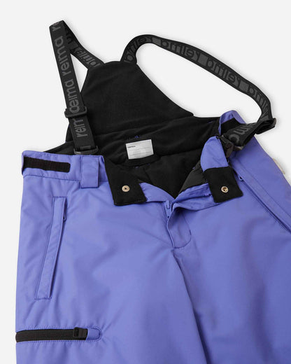 Close-up detail of the front waist on the breezy violet Reima Terrie kids' ski pants, showing the secure snap buttons, smooth zipper fly, soft inner lining, and the front attachment points for the adjustable suspenders.