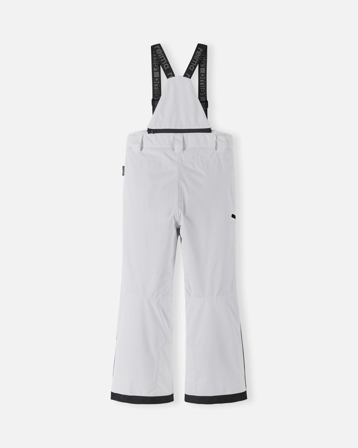 Back flat lay view of the bright white Reima Terrie kids' ski pants, showcasing the high-back coverage, elastic waistband, and heavy-duty black reinforced lower legs built for rugged winter sports.