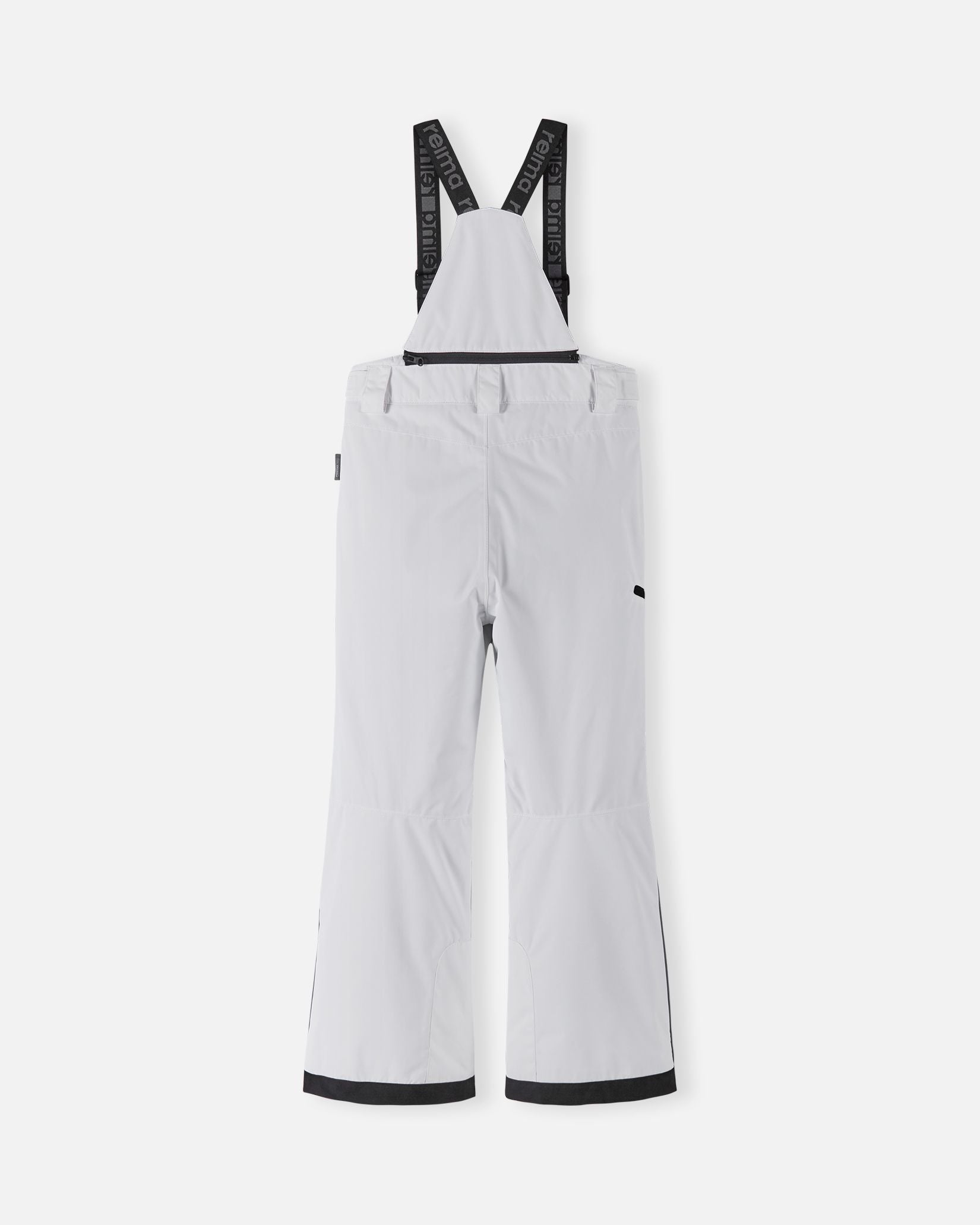 Back flat lay view of the bright white Reima Terrie kids' ski pants, showcasing the high-back coverage, elastic waistband, and heavy-duty black reinforced lower legs built for rugged winter sports.