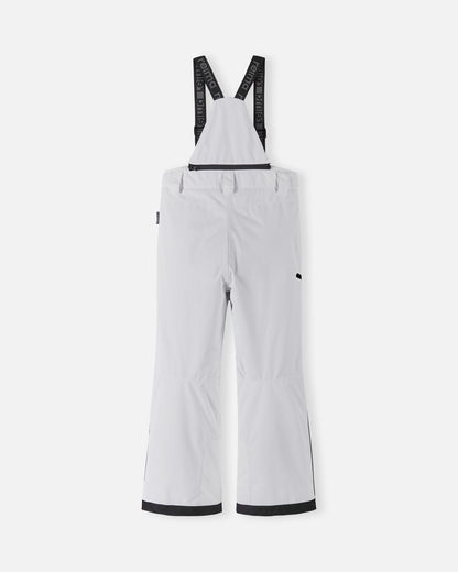 Back flat lay view of the bright white Reima Terrie kids' ski pants, showcasing the high-back coverage, elastic waistband, and heavy-duty black reinforced lower legs built for rugged winter sports.