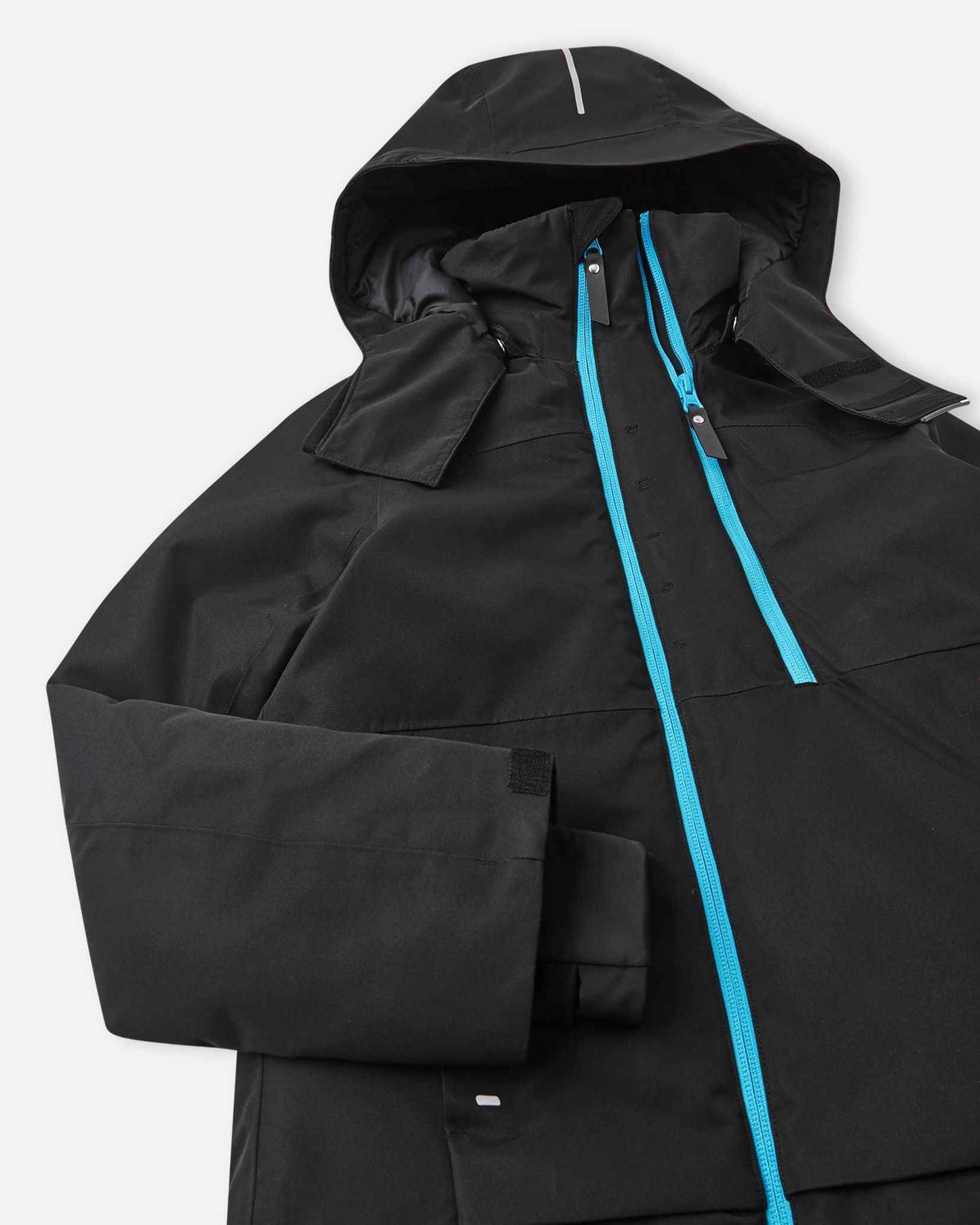 A black Reima Tieten winter coat with the hood pulled up reveals a bright blue inner lining near the top zipper.