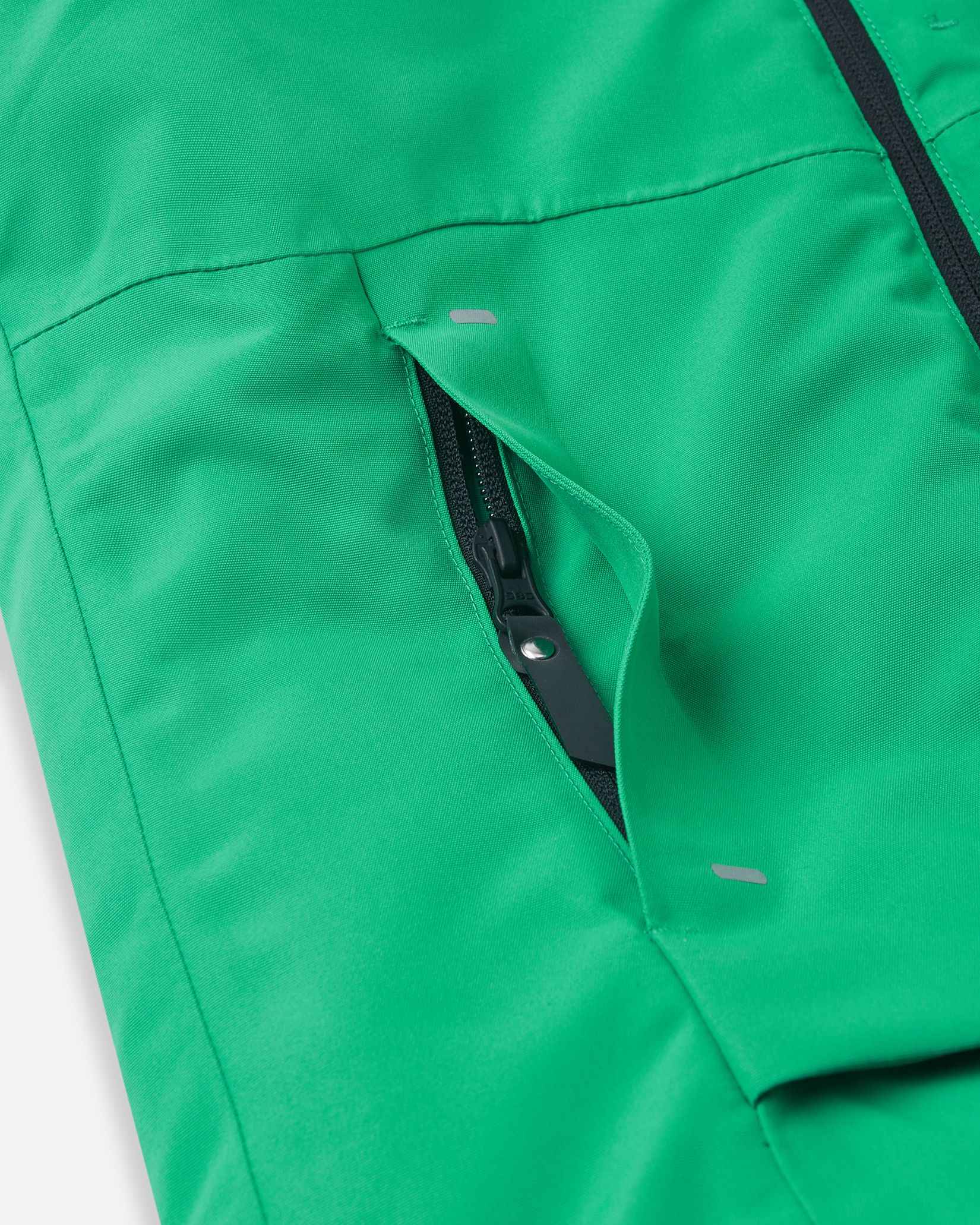 A close view reveals the lower black zipper pocket on the green Tieten kids ski jacket.