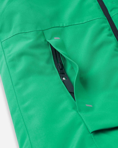 A close view reveals the lower black zipper pocket on the green Tieten kids ski jacket.