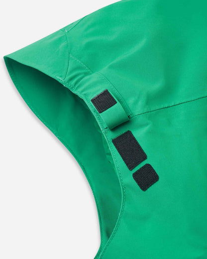 The side of the green Reima Tieten ski jacket hood shows a black velcro adjustment strap.