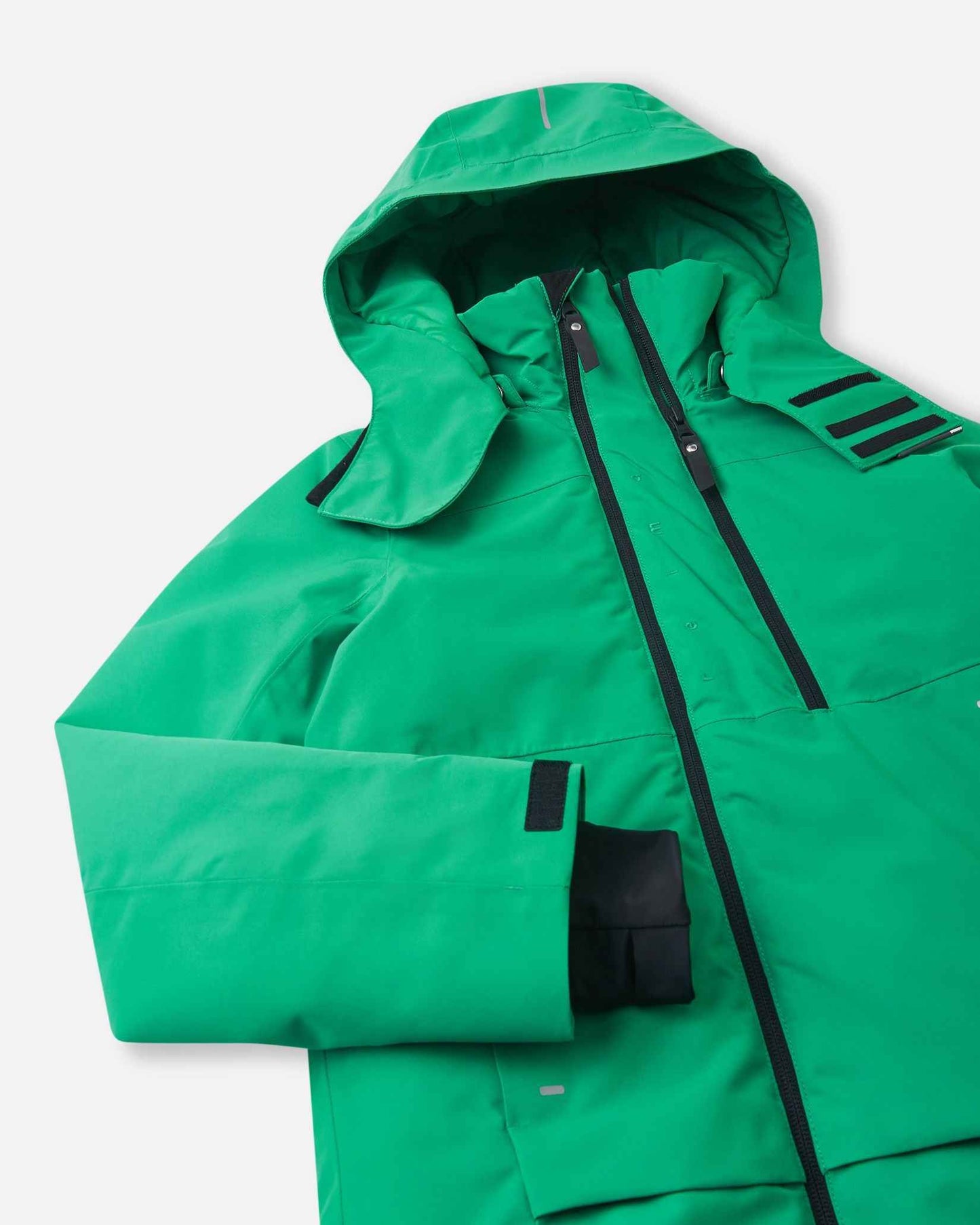 A side view of the green Reima winter coat highlights the shaped hood and adjustable sleeve cuffs.