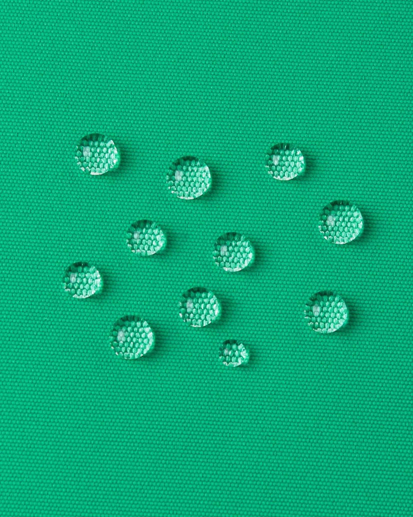 Drops of water sit on the green outer material of the Reima winter jacket.